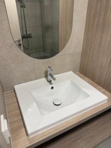 a white sink in a bathroom with a mirror at Nida & Sunrise *Self Check-In* in Nida +32 photos
