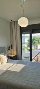 a bedroom with a large bed and a large window at Xenia Residence in Faliraki