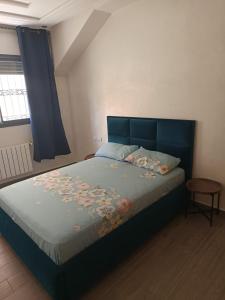 a bedroom with a large bed with a blue headboard at Le Refuge de Vittel 5 in Ifrane