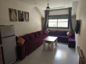 a living room with a purple couch and a table at Le Refuge de Vittel 5 in Ifrane