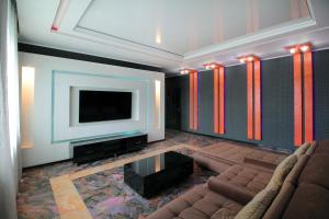 a living room with a couch and a flat screen tv at 3х комнатная 2 спальни Арбат ЖК Столичный центр in Almaty