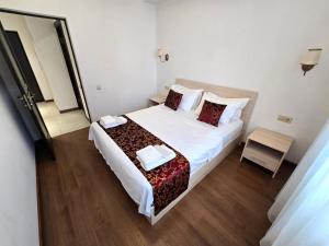 a bedroom with a large white bed with red pillows at Ararat View Apartments in Yerevan