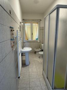 a bathroom with a shower and a sink and a toilet at Appartamento Morelli Beach - Via Giacomelli 55 in Follonica
