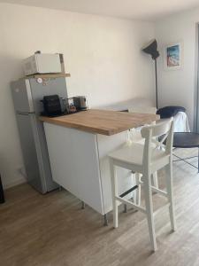 a kitchen with a table and a refrigerator and a chair at Carqueiranne in Carqueiranne +2 photos
