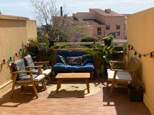 a patio with a blue couch and two chairs at Carqueiranne in Carqueiranne