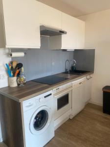a kitchen with a washing machine and a sink at Carqueiranne in Carqueiranne