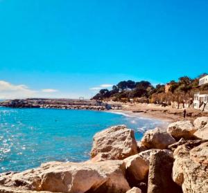 a view of a beach with rocks and the ocean at Carqueiranne in Carqueiranne