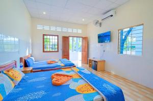 une chambre avec deux lits et un réfrigérateur dans l'établissement Seahorse Bay Phú Quốc, à Duong Dong