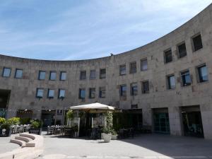 duży kamienny budynek ze stołami i parasolem w obiekcie Giovanna's House w mieście Matera