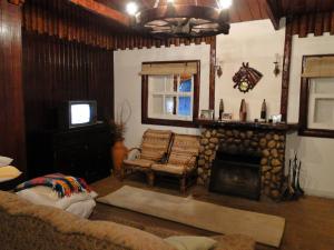 sala de estar con sofá y chimenea en Cabana Do Vale Encantado, en Campos do Jordão