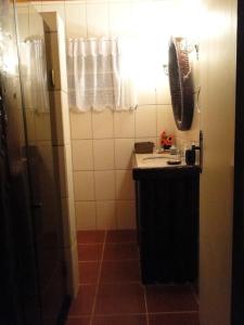 y baño pequeño con lavabo y ducha. en Cabana Do Vale Encantado, en Campos do Jordão