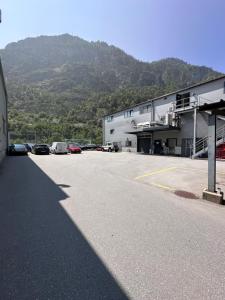 um estacionamento com carros estacionados em frente a um prédio em Topspot Wallis 30 min nach Zermatt oder SaasFee em Stalden