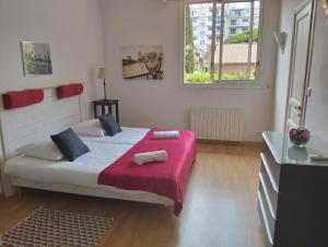 een slaapkamer met een groot bed met een rode deken bij Villa HELIOS in Cannes