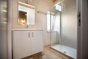 a bathroom with a shower and a sink and a mirror at Atelier Residences by Sweet Keys in Limassol +32 photos
