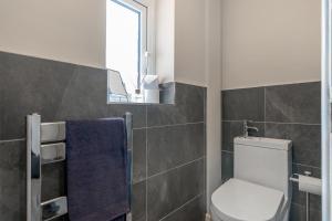 ein Badezimmer mit Toilette und Fenster in der Unterkunft 4 bedroom Pitchford in Earlham