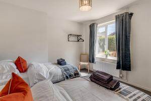 ein Wohnzimmer mit 2 Betten und einem Fenster in der Unterkunft 4 bedroom Pitchford in Earlham