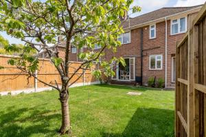 ein Haus mit einem Baum im Hof in der Unterkunft 4 bedroom Pitchford in Earlham