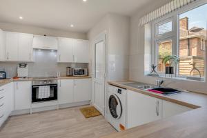 eine Küche mit weißen Schränken und einer Spüle in der Unterkunft 4 bedroom Pitchford in Earlham + 10 Fotos