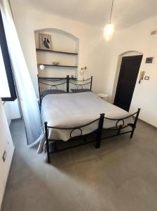 ein Schlafzimmer mit einem schwarzen Bett in einem Zimmer in der Unterkunft Appartamento dei limoni in La Spezia