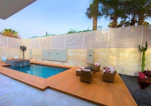 a swimming pool with two chairs and a table at Villa Sable de Mirleft Luxury Apartment in Mirleft