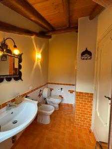 a bathroom with two toilets and a tub and a sink at Zest House in Santa Venerina