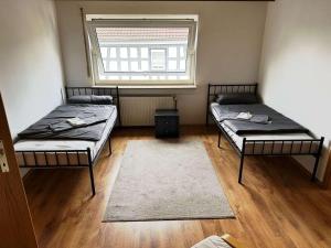 zwei Betten in einem Zimmer mit Fenster in der Unterkunft Stay & Relax Apartment in Flörsheim am Main in Flörsheim