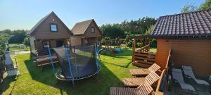 een achtertuin met een schommel en een speeltuin bij Domki Milena in Mieroszyno