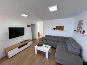 a living room with a couch and a flat screen tv at The Whiter House in Gáldar