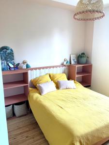 a bedroom with a yellow bed with two pillows at Inspired space in Le Mans