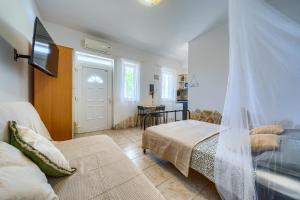 a bedroom with a bed and a couch and a tv at VILA SENTIO MARE-Apartments Livaić Željko in Pirovac +100 photos