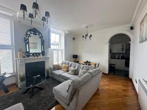 a living room with a couch and a fireplace at Cute and Comfy Apartment in Saint Helier Jersey
