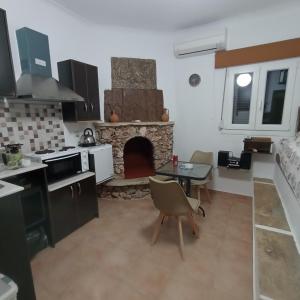 a kitchen with a table and a stone fireplace at Porto Mesta Residence in Thasos +16 photos