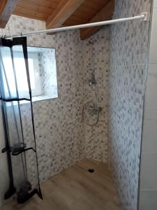 Un baño con ducha en una pared de ladrillo. en el apartamento de zocas, en O Barqueiro 1 foto más