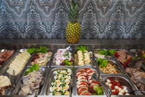 Un buffet lleno de diferentes tipos de comida y una piña. en Moris Beach Hotel, en Gdansk