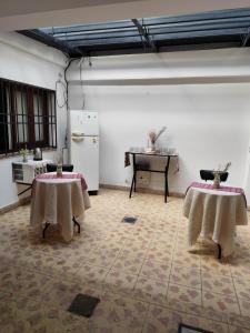 a room with two tables and a refrigerator at Cerro del sol, habitaciones privadas in Salta