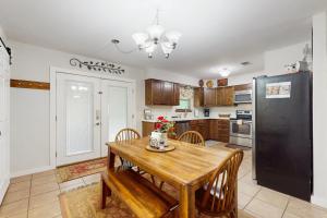 a kitchen with a wooden table and a black refrigerator at Arroyo Haus in Fredericksburg