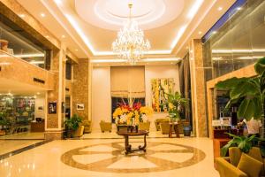 een lobby met een tafel en een kroonluchter bij Muong Thanh Vung Tau Hotel in Vung Tau