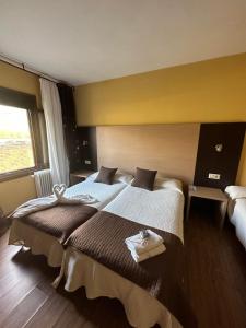 ein Hotelzimmer mit zwei Betten und einem Fenster in der Unterkunft Casa Blanco Conde in Laza
