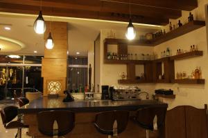 a kitchen with a bar with chairs and lights at Quaint Hotel Erbil in Erbil