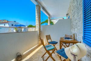 a balcony with two chairs and a table on a wall at VILA SENTIO MARE-Apartments Livaić Željko in Pirovac