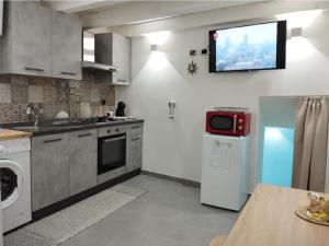 a kitchen with a television on the wall at The Cordari House in Siracusa