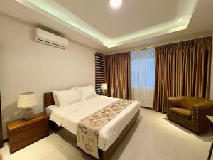 une chambre d'hôtel avec un lit et une chaise dans l'établissement Sheryll Escapes - La Grande Poolside 1 BR with Bathtub, WiFi & Netflix, à Ángeles