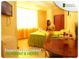 een vrouw op een bed in een hotelkamer bij Hotel Alfredos in Pucallpa