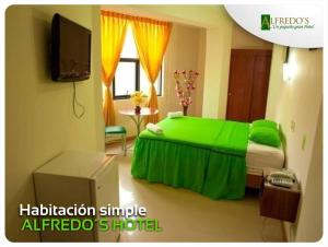 ein Schlafzimmer mit einem grünen Bett und einem Fernseher in der Unterkunft Hotel Alfredos in Pucallpa