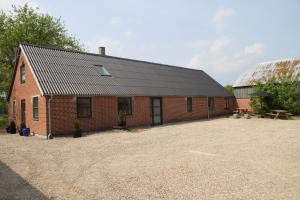 a red brick building with a black roof at Hukaergaard Bed & Breakfast in Østbirk