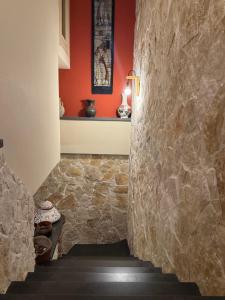 a hallway with a stone wall and a staircase at Zest House in Santa Venerina +53 photos