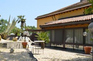 a house with a patio with a table and chairs at Zest House in Santa Venerina