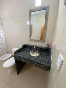 a bathroom with a sink and a toilet and a mirror at Balcón a las sierras - Cervantes 273 - La Falda in La Falda +28 photos