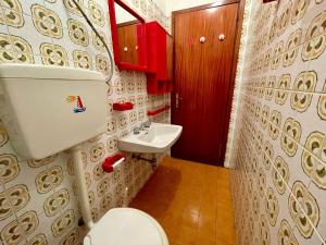 a bathroom with a toilet and a sink at Townhouse with private garden in Porto Santa Margherita di Caorle +16 photos