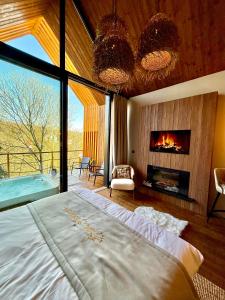 a bedroom with a large bed and a fireplace at Erdei Szelencék in Sukoró +20 photos